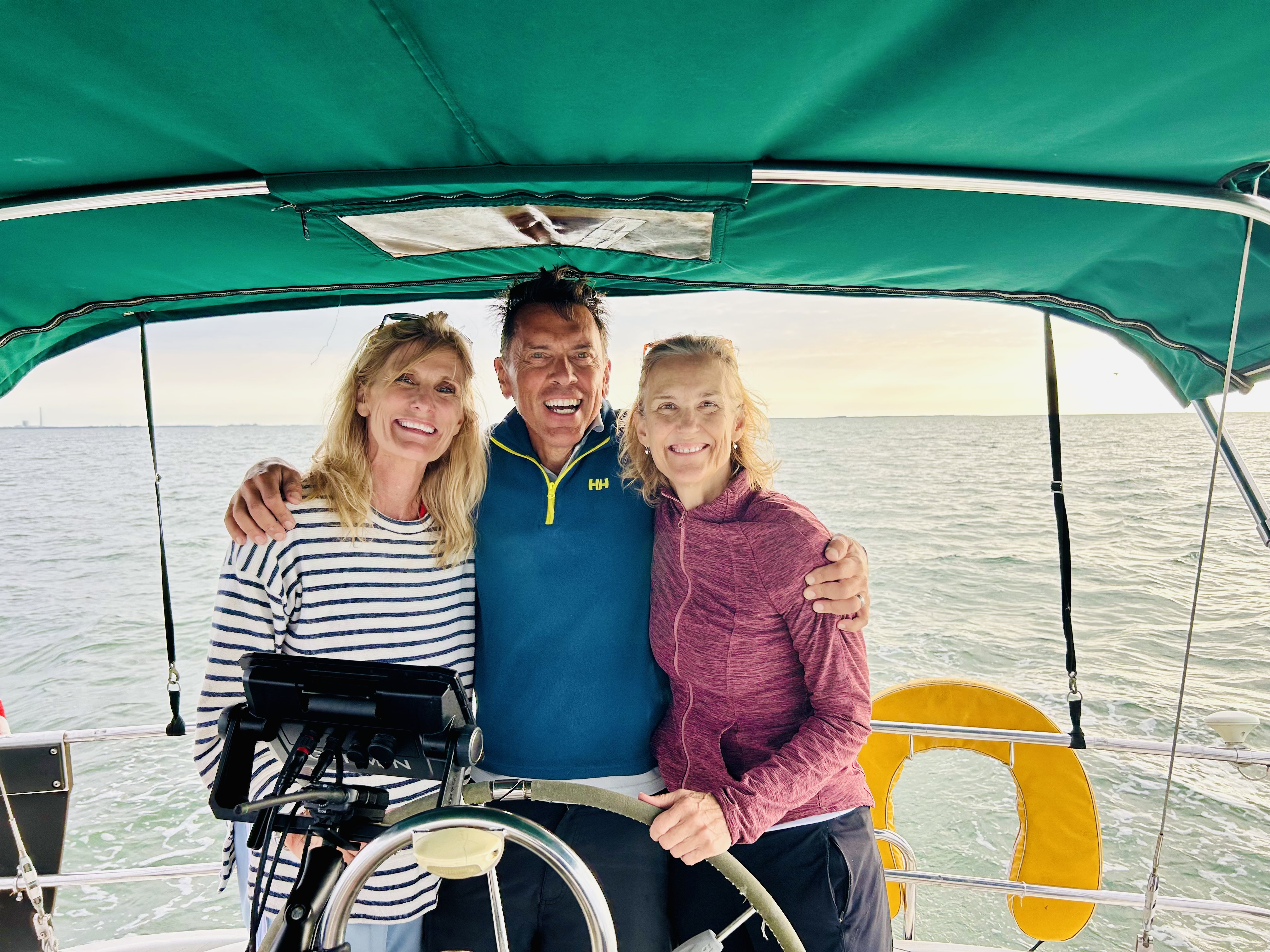 Clay, Jodi, and guests enjoying sailing at the wheel